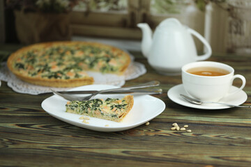 Delicious Quiche pie with salmon fish and pine nuts filling. Breakfast with quiche and cup of tea