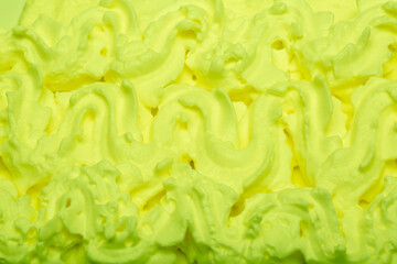 Cake cream texture, sweet whipped cream. Background of yogurt close-up with a pattern. Pistachio mousse.