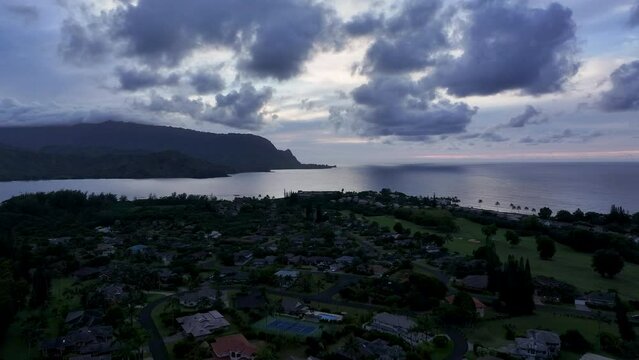 Aerial Kauai beautiful Hanalei Bay ocean evening pull. Beautiful fluffy clouds drifting over the Hawaiian Islands Pacific Ocean. Sunset colors, shades of blue. Atmosphere weather meteorology.