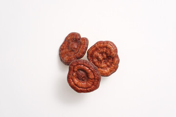 Top view of three lingzhi mushrooms isolated on a white background. Scene for advertising with rare herbal ingredient. Ganoderma help improve the immune system, reduce stress and fatigue