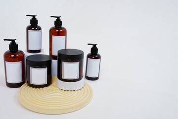 Body care. a set of bottles with dispensers and jars of body cream on a geometric stand and on a light gray background. Advertising concept
