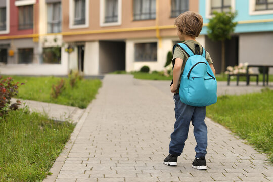 Little boy walking to kindergarten outdoors, back view. Space for text