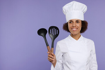 Happy female chef in uniform holding skimmer and ladle on purple background. Space for text