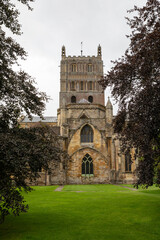 A side elevation of the Abbey Church of St Mary the Virgin better known as Tewksbury abbey framed by trees - 682125910