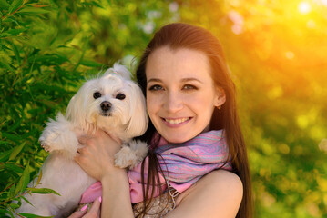 Young girl with her dog. Puppy white dog is running with it's owner. Concept about friendship, animal and freedom.