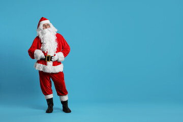 Merry Christmas. Santa Claus posing on light blue background, space for text