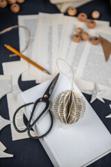  Person bastelt aus Buchseiten Wabenb&auml;lle f&uuml;r Weihnachten, Dekoration Weihnachtsbaum selber machen, basteln, zeichnen, falten kleben Christbaumschmuck