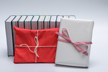 Książki zapakowane na prezent w papier pakowy, owinięte wstążką z kokardą - obrazy, fototapety, plakaty