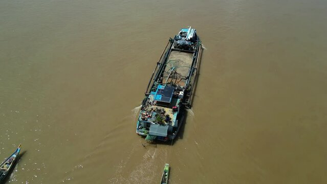 Drone footage above a boat who carry sand and a fisherman boat coming along. We re few kilometers from Phnom Penh, Cambodia