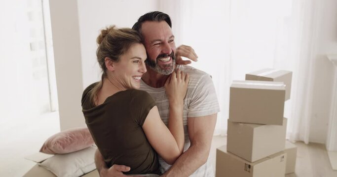 Couple, hug and living room with box in new home for real estate, mortgage and property investment. People, man and woman with embrace, happy and moving into apartment, house or relocation with smile