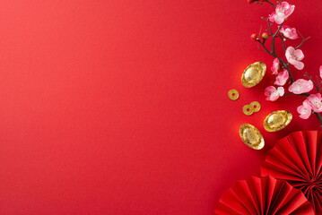 Immerse yourself in Chinese New Year ambiance through this top-view arrangement featuring fans, Feng Shui items, symbolic coins, sycee and sakura blooms on red setting, ready for text or advertising