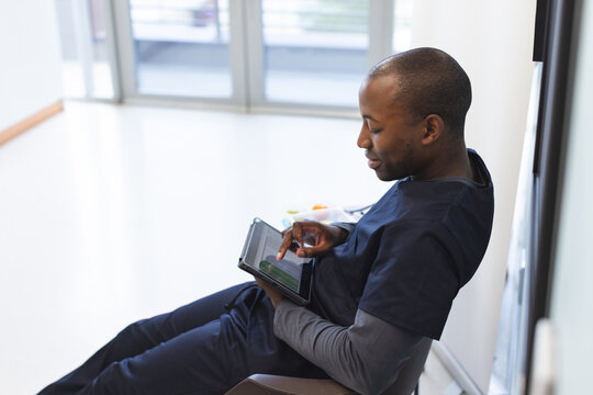 African american male doctor using tablet in waiting room in hospital