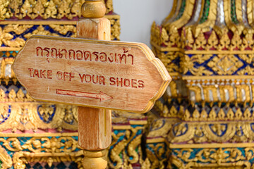Sign at a Buddhist temple asking people to take off their shoes, Wat Pho, Bangkok, Thailand