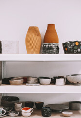 Pottery tablewares on shelves of small art shop.
