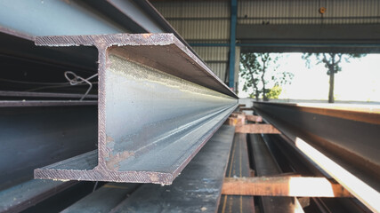 Steel beams production. Metal girders stack on project construction , steel h-beam, selective focus, Raw materials used in building construction.