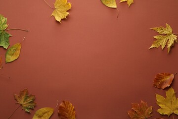 Dry autumn leaves on brown background, flat lay. Space for text