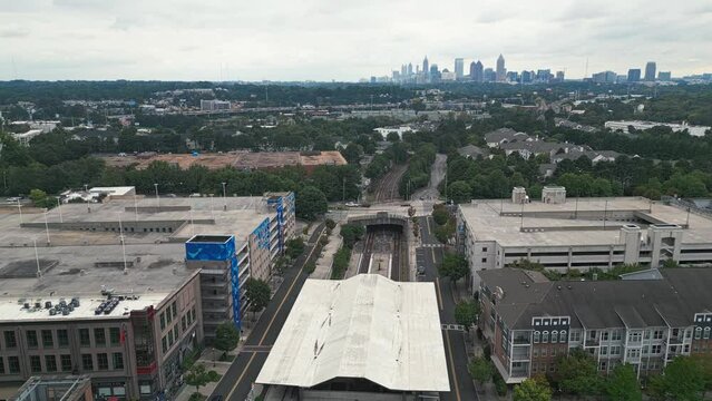 Aerial approaching shot of Lindbergh Marta Station and Skyline of Atlanta City in background during cloudy day