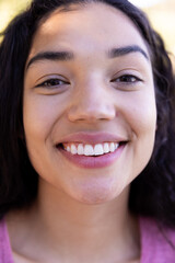 Close up portrait of happy biracial woman in sunny nature