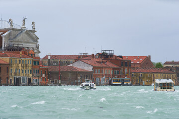 Water taxis cruising between Venetian islands in Guidecca canal. Traditional transport in Venezia. Venice - 5 May, 2019