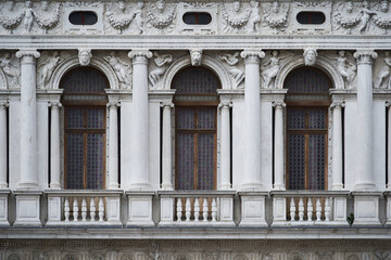Tall windows in gothic style on the Doge's Palace (Italian: Palazzo Ducale), one of the main Venetian landmarks. Venice - 5 May, 2019