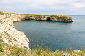 Cape Tarkhankut on the Crimean peninsula. The rocky coast of the Dzhangul Reserve in the Crimea. The Black Sea. Turquoise sea water. Rocks and grottoes of Cape Tarkhankut.