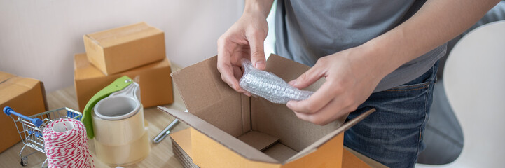 Efficient Home-Based Delivery, Man Packing Items into Post Box for Customer Shipping, Online...