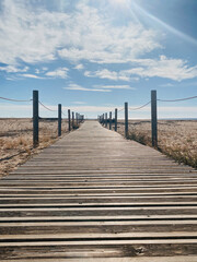 Obraz premium Wooden path on the beach to reach the sea.