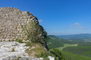 Ancient buildings cave fortress city Mangup-Kale, sunny day. Mountain view from the ancient cave town of Mangup-Kale in the Republic of Crimea, Russia. Bakhchisarai.