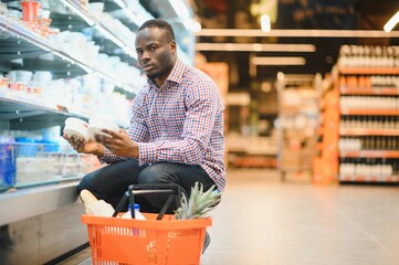 Attractive african american man shopping in a supermarket