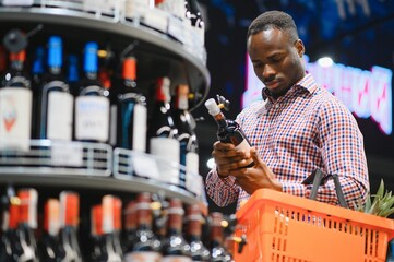 African American Man in a supermarket choosing a wine