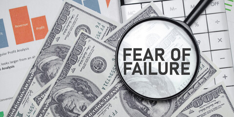 FEAR OF FAILURE word on magnifying glass with dollars and charts