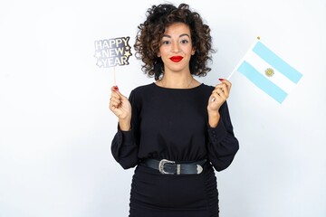 Young beautiful woman with curly hair wearing black dress, Argentinian flag and a Happy new year...
