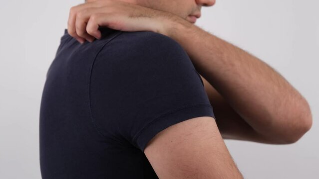 man itching shoulder
