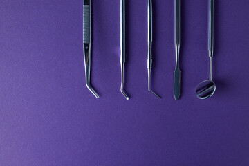 Dental tools on violet background