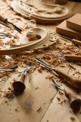 Experienced carpenter shapes wood with a chisel. Wooden table with a set of different chisels for woodcarving