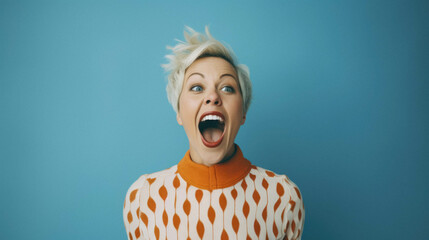Beautiful middle age senior woman wearing elegant yellow coat and hat over isolated yellow background amazed and surprised looking up and mouth with fingers and raised arms with.