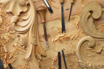 Hands of craftsman carve with a gouge in the hands on the workbench in carpentry. Wood carving...