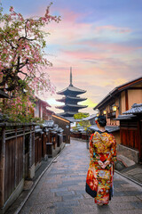 Young Japanese woman in traditional Kimono dress with Yasaka Pagoda at Hokanji temple in Kyoto, Japan during full bloom cherry blossom in spring - 682184946