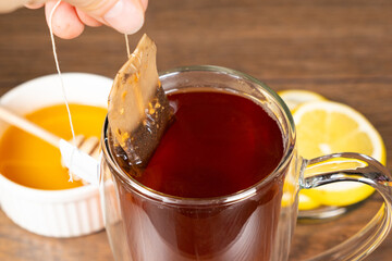 Preparation tea from a tea bag in a glass cup.