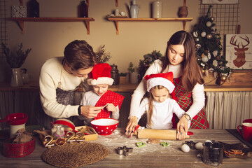 Young man and girl  teach children how to cook cookies in the kitchen.
