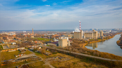 Aerial view of industrial complex thermal power plant with tall chimney in winter