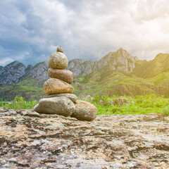 A high tower of flat stones stands on the seashore in cloudy weather
