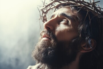 Jesus with bloody crown of thorns on His head over light background. Jesus Christ in agony praying before crucifixion. Good Friday, Passion, Easter concept. Gospel, salvation