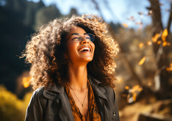 happy young black woman enjoying nature in a park under the sun's rays, concept of calm happiness and freedom