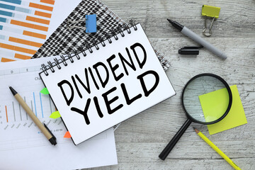 DIVIDEND YIELD financial charts. paper with text on a notepad