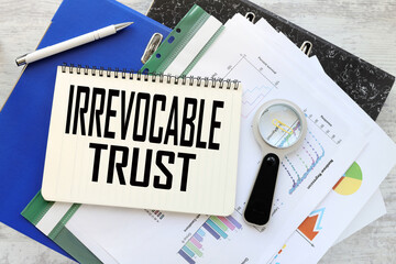 Irrevocable trust work desk blue folder blue financial charts. text on a notebook