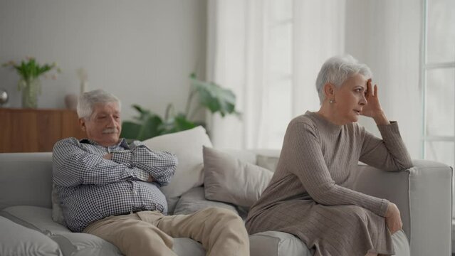 Senior sad couple separate on couch ignoring each other, avoid talking after fight and quarrel. Wife and husband have misunderstandings, experiencing relationship crisis. Upset elderly family at home.