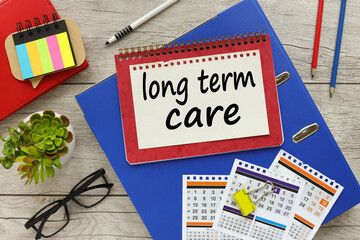 top view of the folder calendar pencils and pens. text long-term care