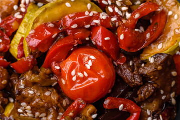 Warm salad with veal, tomatoes, peppers, zucchini, sesame, salt, spices and herbs