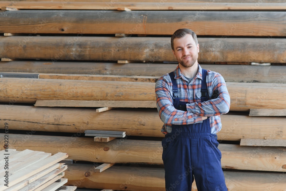 Wall mural Carpenter in uniform check boards on sawmill